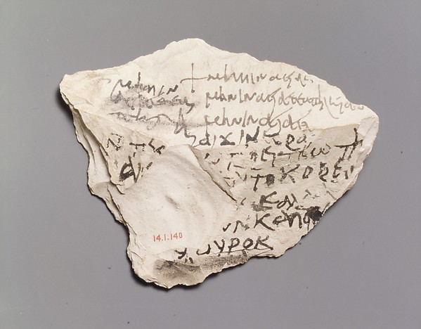 白い石のかけらに、黒いインクでギリシャ文字が何行も書かれている